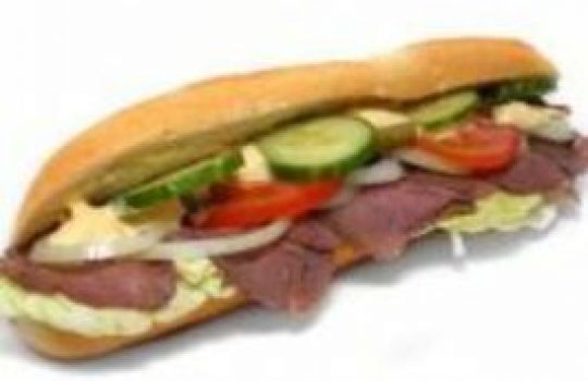 Ein Baguette ist belegt mit Salami, Käse, Tomaten und Gurken.