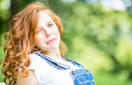 Portrait einer Frau mit langen roten Haaren.