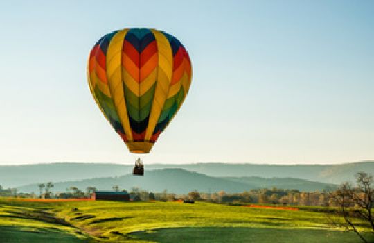 Bunter Heißluftballon muss Ballast abwerfen, damit er wieder steigen kann.